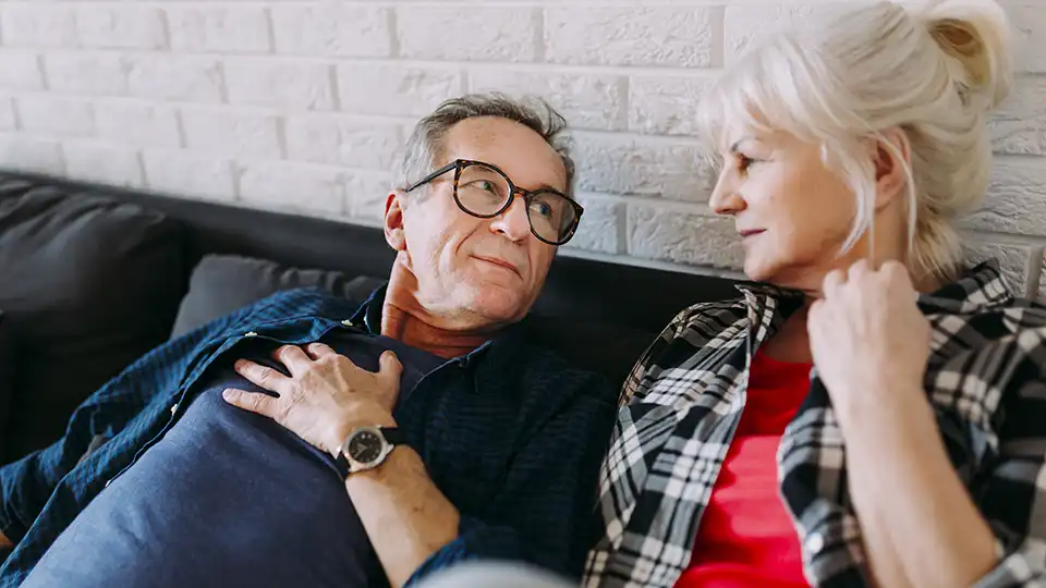 Middle-aged couple having a conversation on the sofa.