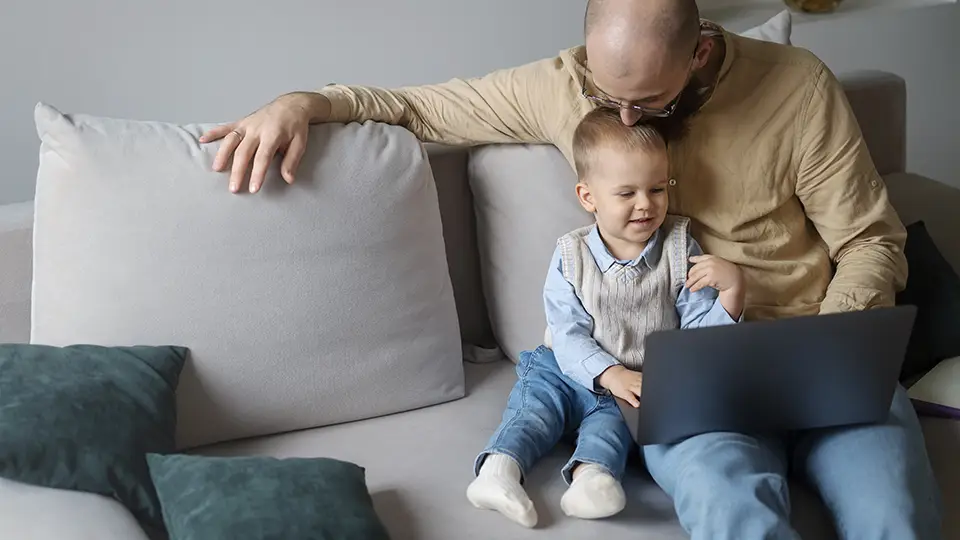 Father and toddler son watching a laptop together.